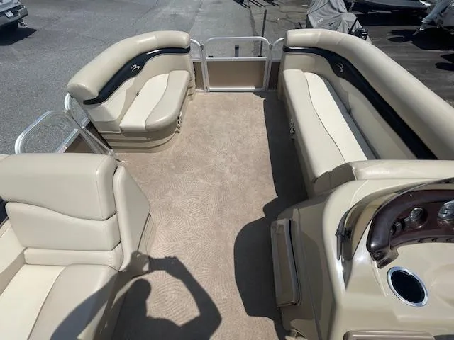 Slide: The Image of 2011 Bennington LSI pontoon boat interior with beige seating and steering console. - 6