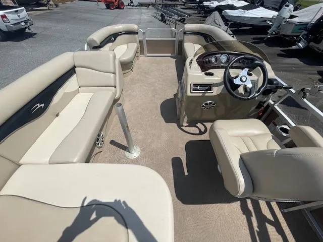 Slide: The Image of 2011 Bennington LSI pontoon boat interior with beige seating and steering console. - 7