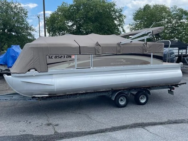Slide: The Image of 2011 Bennington LSI pontoon boat on trailer, covered, parked outdoors. - 8