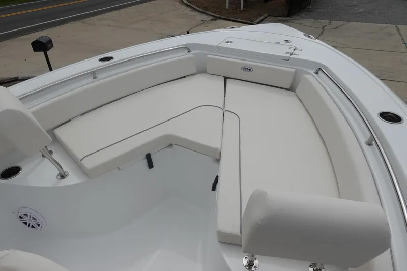Slide: The Image of 2026 Sea Hunt Ultra 229 boat interior with white cushioned seating and stainless steel railings. - 24