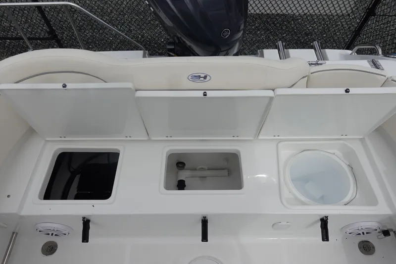 Slide: The Image of 2026 Sea Hunt Ultra 229 boat with open storage compartments and seating area. - 9