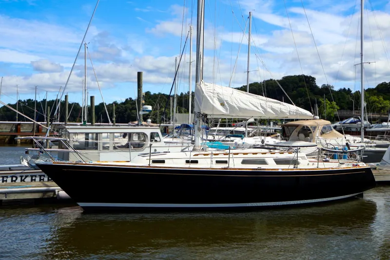 The Image of 1987 Sabre 36 Sloop sailboat docked at marina under blue sky. - 1