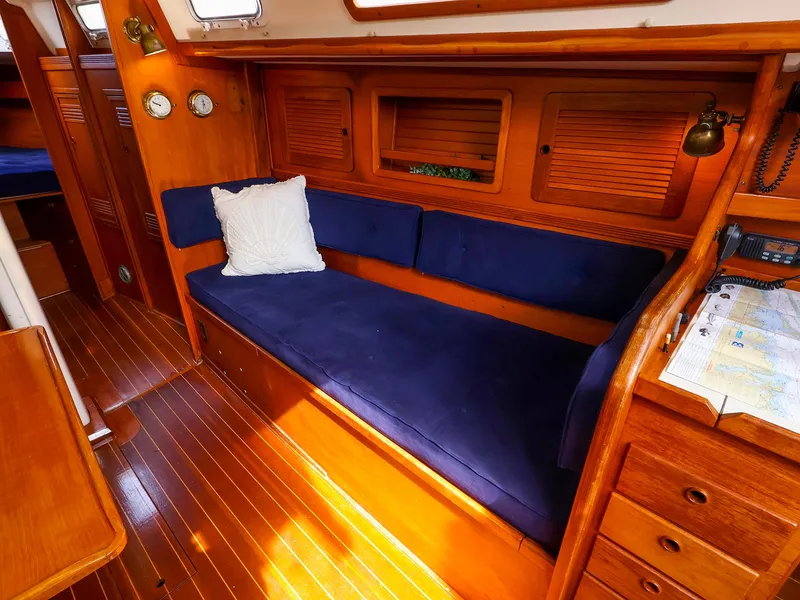 Slide: The Image of Interior of 1987 Sabre 36 Sloop with blue cushions and wooden cabinetry. - 26