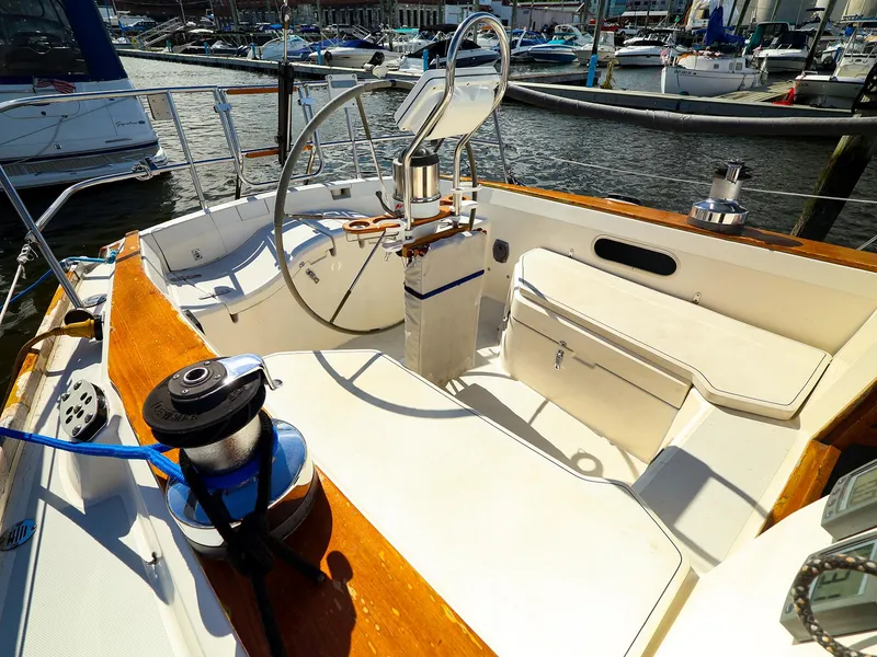 Slide: The Image of 1987 Sabre 36 Sloop cockpit with steering wheel and winches, docked at marina. - 4