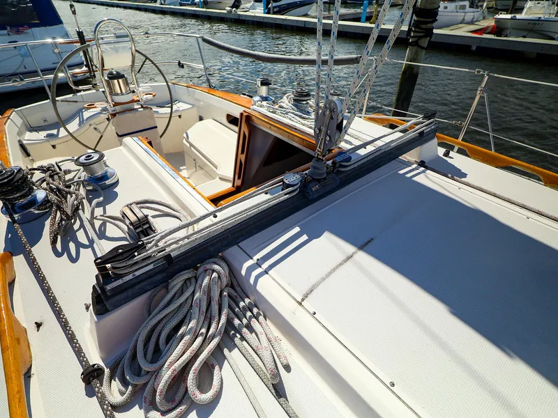 Slide: The Image of 1987 Sabre 36 Sloop sailboat deck with ropes and steering wheel in marina. - 11