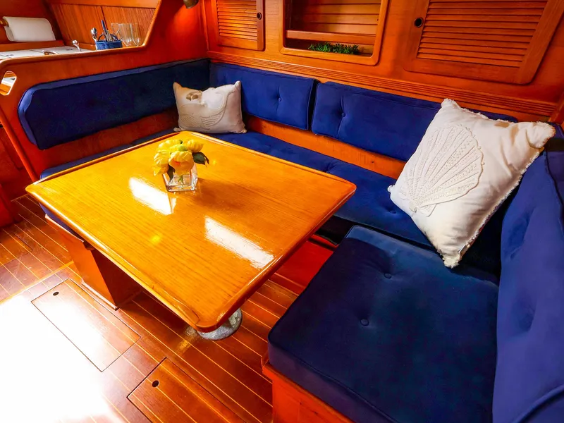 Slide: The Image of Cozy interior of 1987 Sabre 36 Sloop with blue cushions and wooden table. - 28