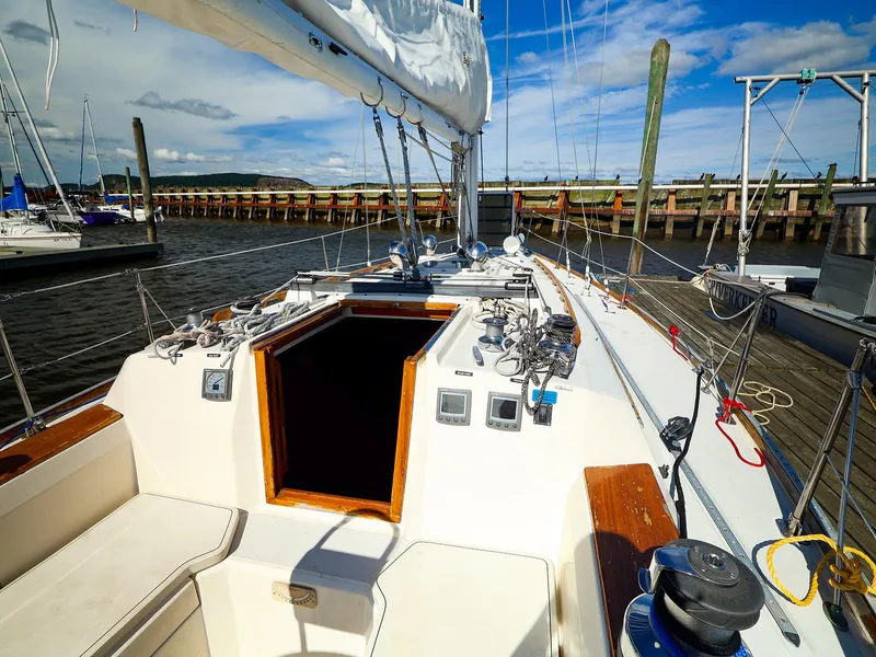 Slide: The Image of 1987 Sabre 36 Sloop sailboat docked, showcasing cockpit and rigging under a clear blue sky. - 3
