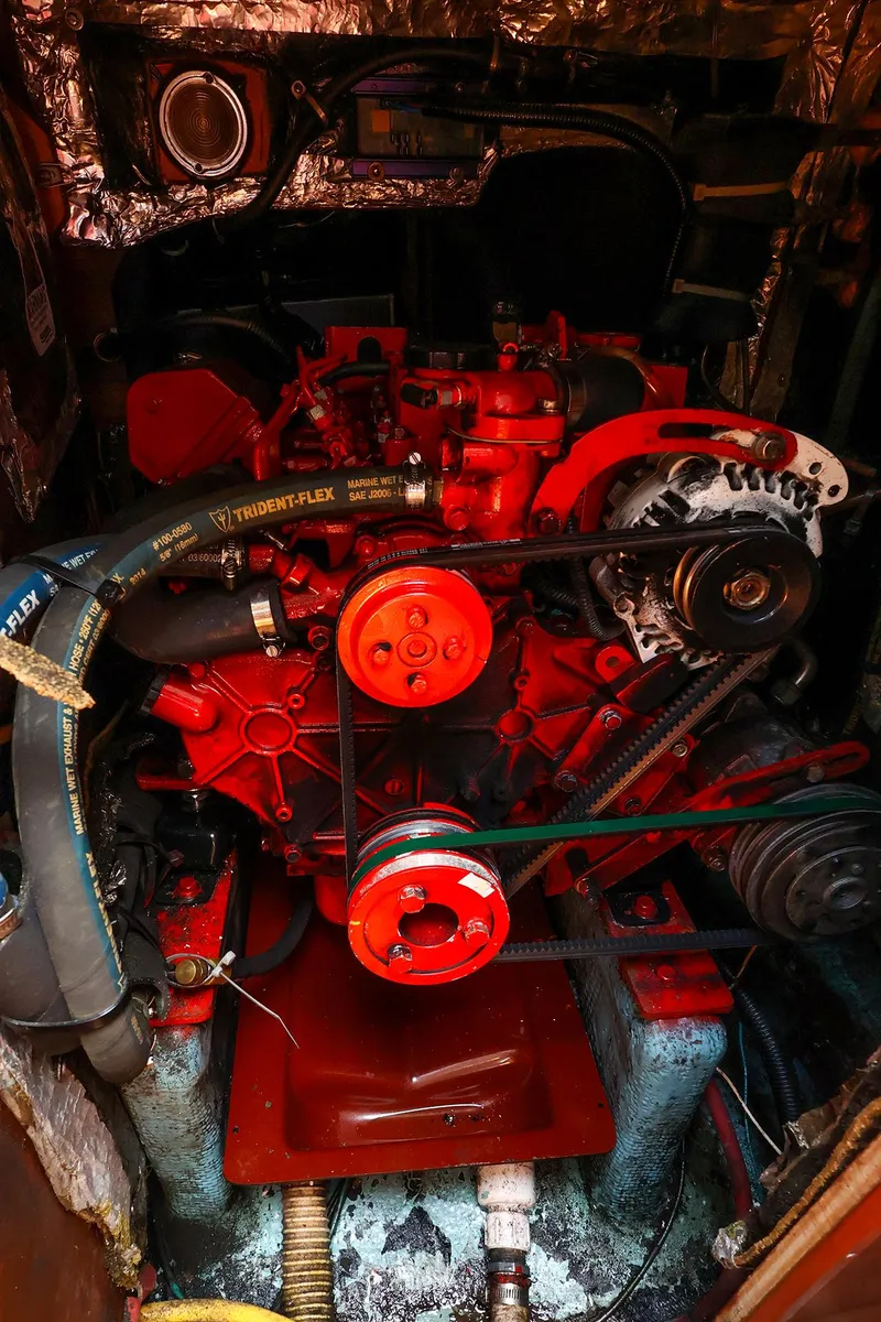 Slide: The Image of Engine compartment of a 1987 Sabre 36 Sloop, featuring a red marine engine. - 31