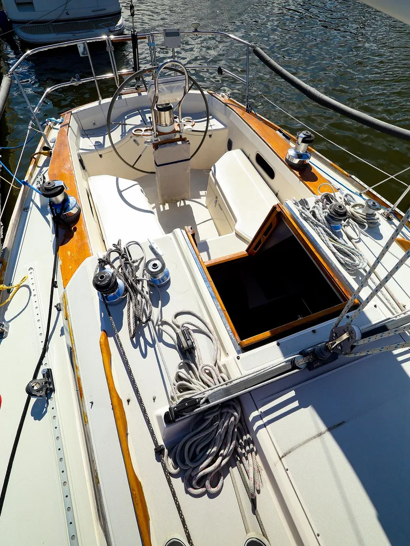 Slide: The Image of 1987 Sabre 36 Sloop sailboat cockpit with steering wheel and rigging, docked on water. - 6