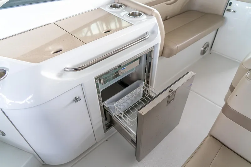Slide: The Image of 2012 Formula 310 Bowrider interior with open mini fridge and beige seating. - 13