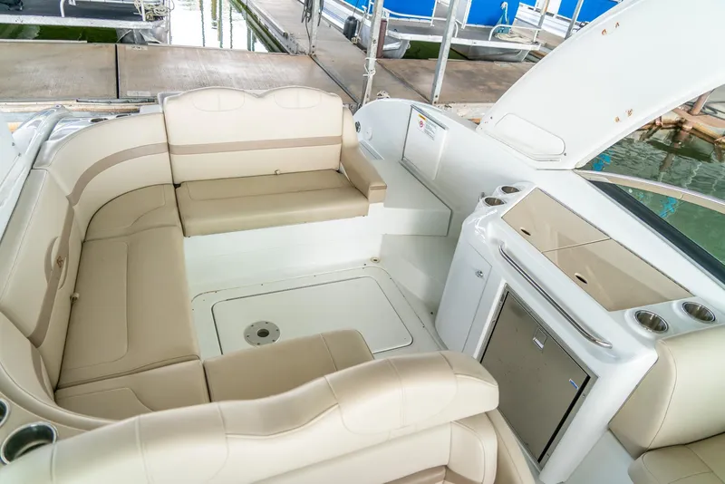 Slide: The Image of 2012 Formula 310 Bowrider interior with beige seating and kitchenette, docked at marina. - 28