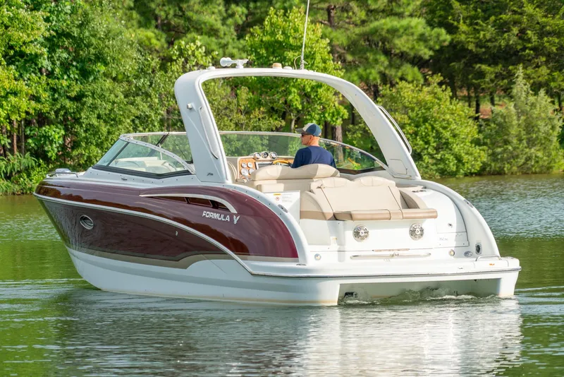 Slide: The Image of 2012 Formula 310 Bowrider cruising on a serene lake surrounded by lush greenery. - 3