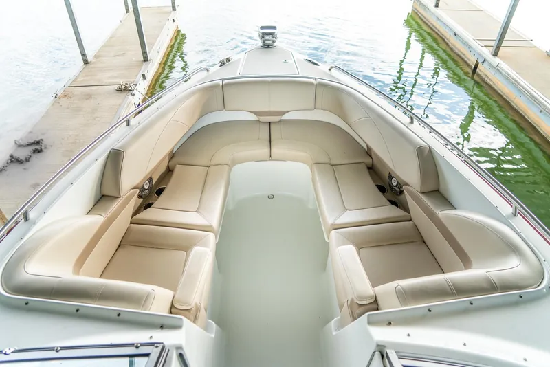 Slide: The Image of 2012 Formula 310 Bowrider boat with spacious beige seating at a dock. - 31