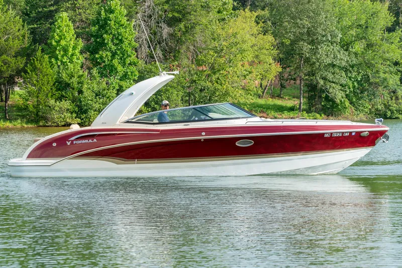 Slide: The Image of 2012 Formula 310 Bowrider cruising on a serene lake with lush green trees. - 5