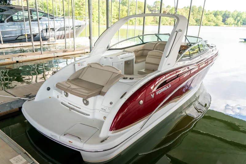 Slide: The Image of 2012 Formula 310 Bowrider boat docked, featuring sleek design and spacious seating. - 7