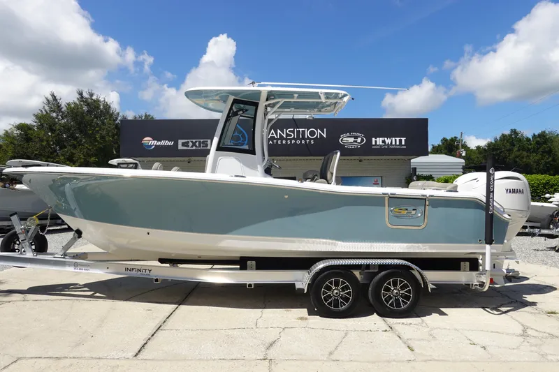 Slide: The Image of 2026 Sea Hunt Ultra 265 SE boat on trailer at dealership, sunny day. - 2