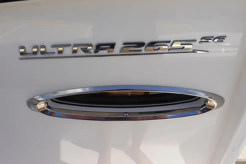 Slide: The Image of 2026 Sea Hunt Ultra 265 SE logo on white surface with chrome detail. - 30
