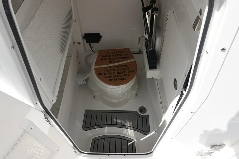 Slide: The Image of Interior of 2026 Sea Hunt Ultra 265 SE boat, featuring a compact restroom area. - 41