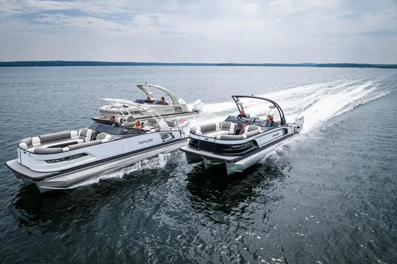 Slide: The Image of Two luxury pontoon boats cruising on a lake, showcasing sleek design and comfort. - 10