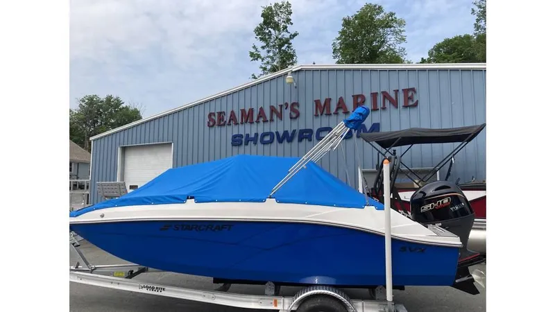 Slide: The Image of 2025 Starcraft SVX 171 OB boat with blue cover at Seaman's Marine showroom. - 4