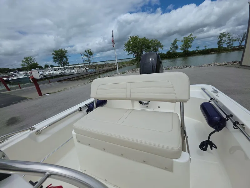 Slide: The Image of 2024 Boston Whaler 150 Montauk boat interior with seating, dockside view. - 12