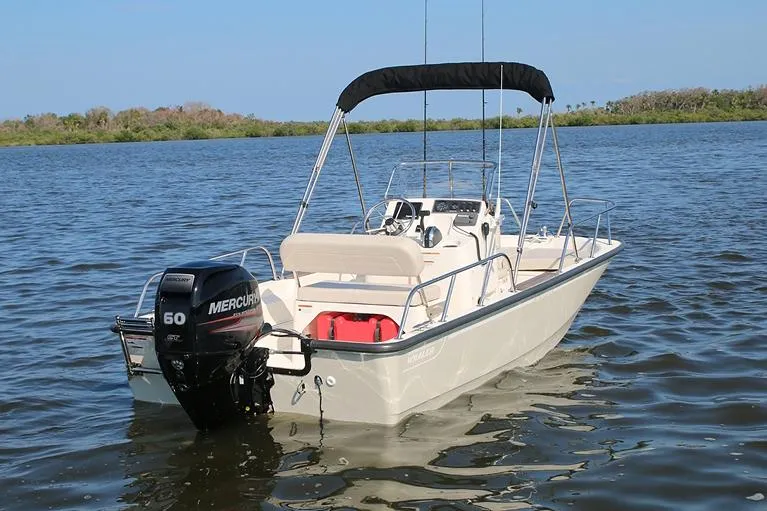 Slide: The Image of Manufacturer Provided Image: 2024 Boston Whaler 150 Montauk boat with Mercury 60 outboard motor on water. - 18