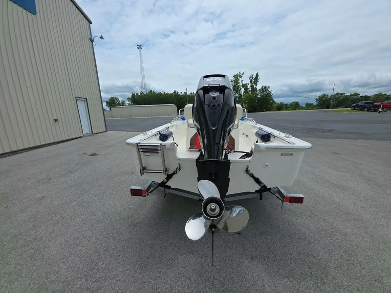 Slide: The Image of 2024 Boston Whaler 150 Montauk boat rear view with outboard motor in parking lot. - 5