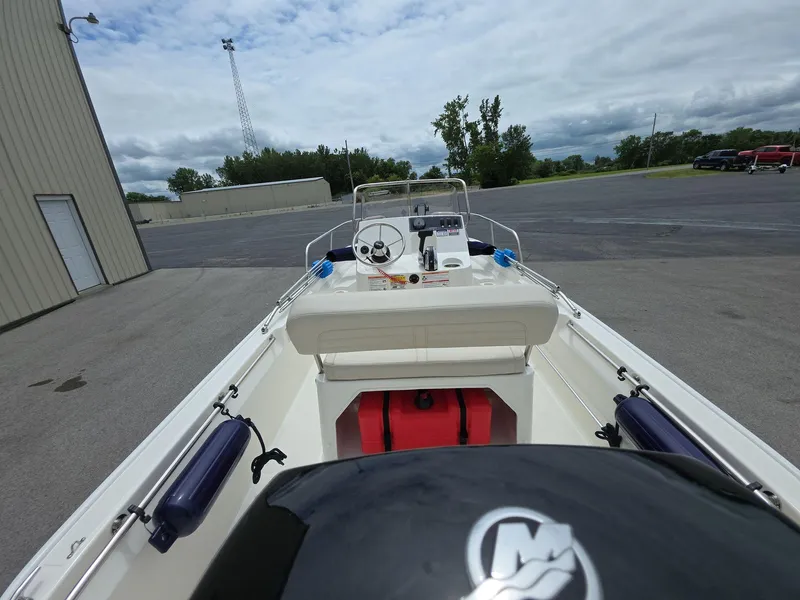 Slide: The Image of 2024 Boston Whaler 150 Montauk boat parked outdoors, showcasing interior and controls. - 7