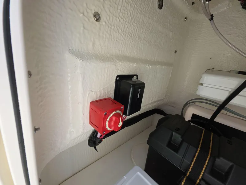 Slide: The Image of 2024 Boston Whaler 150 Montauk interior with red switch and storage compartment. - 8