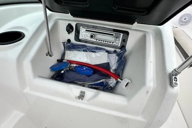 Slide: The Image of 2014 Yamaha SX190 boat storage compartment with stereo and accessories. - 16
