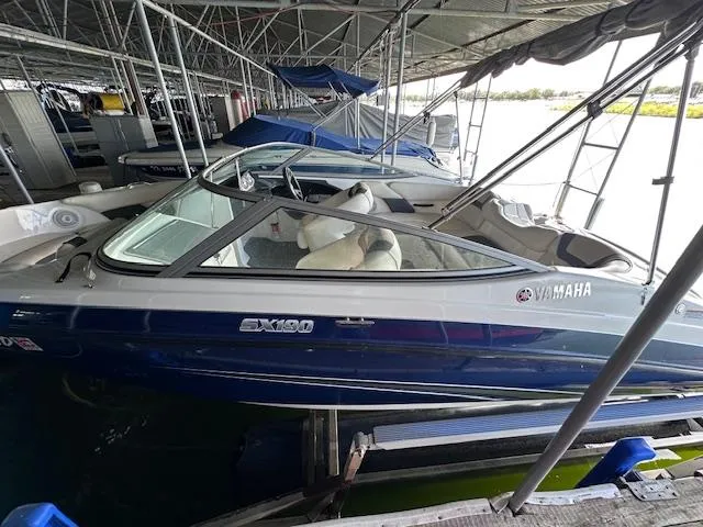 Slide: The Image of 2014 Yamaha SX190 boat docked in a marina, featuring sleek design and blue exterior. - 5