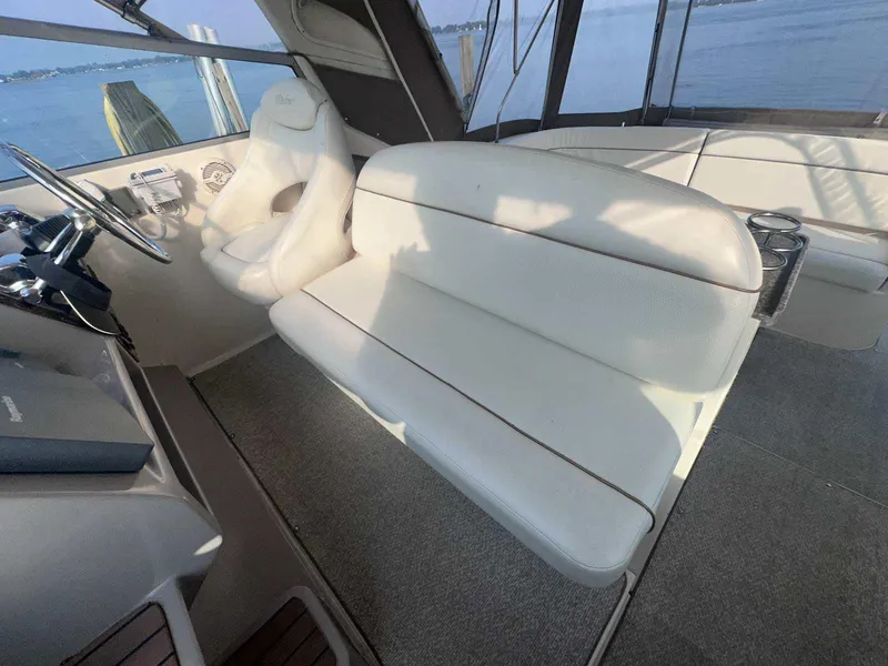 Slide: The Image of 2004 Rinker Fiesta Vee 410 boat interior with white seating and steering wheel. - 11
