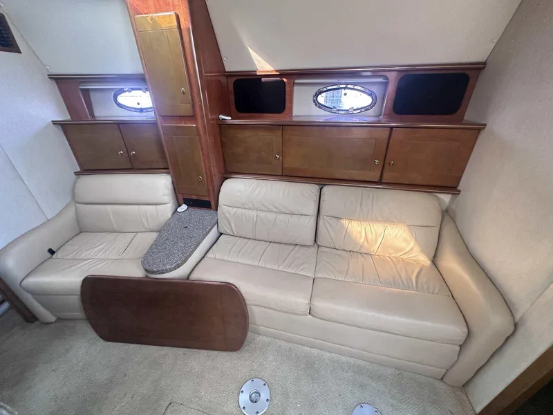 Slide: The Image of 2004 Rinker Fiesta Vee 410 interior with beige leather sofa and wooden cabinets. - 17