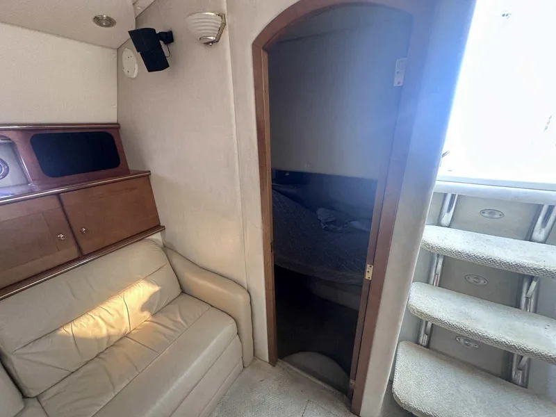 Slide: The Image of 2004 Rinker Fiesta Vee 410 interior with sofa, cabin door, and carpeted stairs. - 18