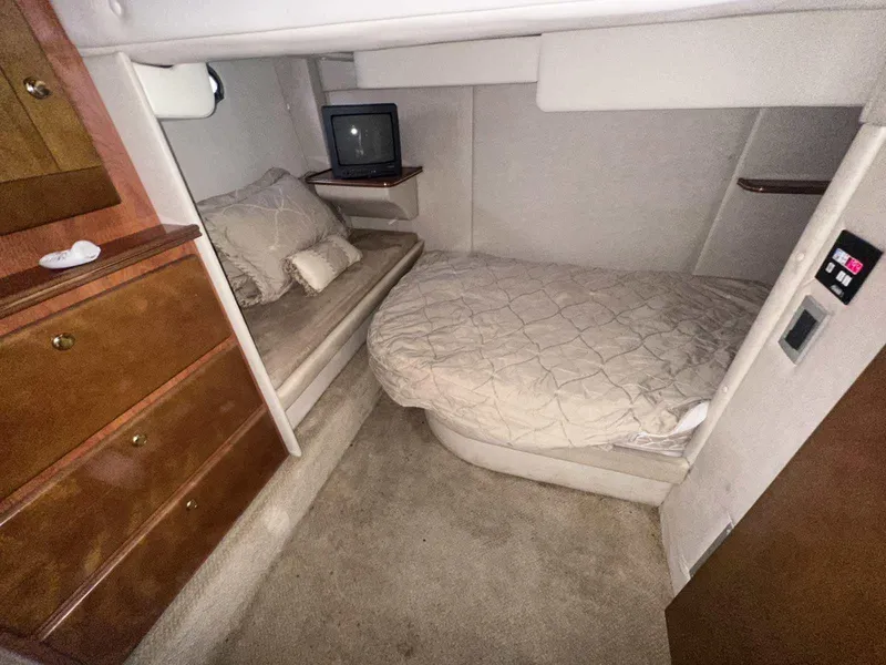 Slide: The Image of 2004 Rinker Fiesta Vee 410 cabin interior with cozy beds and wooden cabinetry. - 19