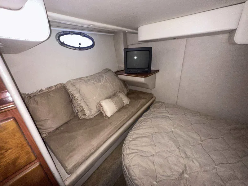 Slide: The Image of 2004 Rinker Fiesta Vee 410 cabin interior with cozy bed, sofa, and small TV. - 20