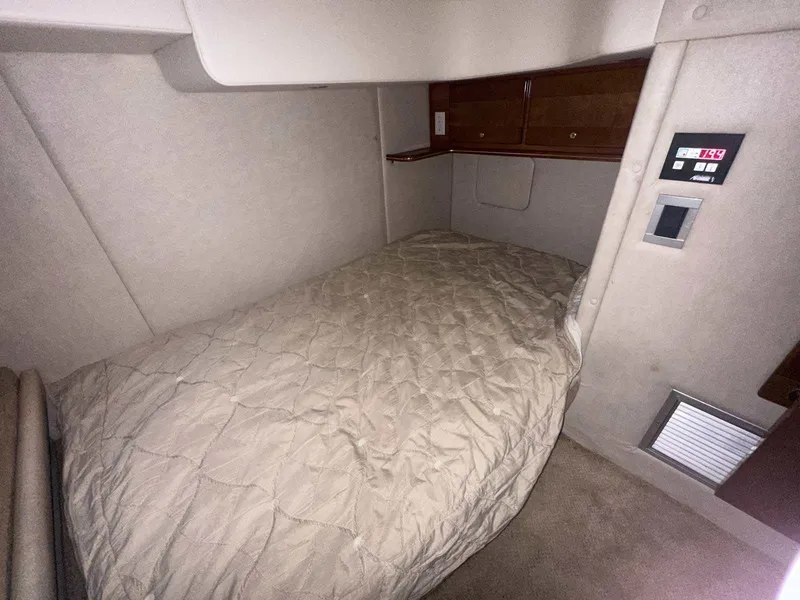 Slide: The Image of 2004 Rinker Fiesta Vee 410 cabin interior with cozy bed and control panel. - 21