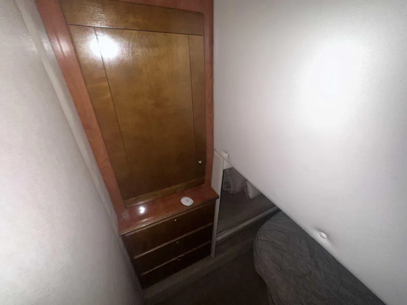 Slide: The Image of 2004 Rinker Fiesta Vee 410 interior with wooden cabinet and bed. - 22