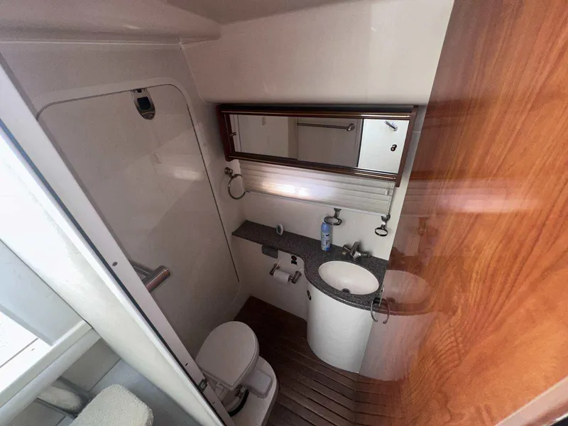 Slide: The Image of 2004 Rinker Fiesta Vee 410 bathroom with sink, toilet, and wooden accents. - 23