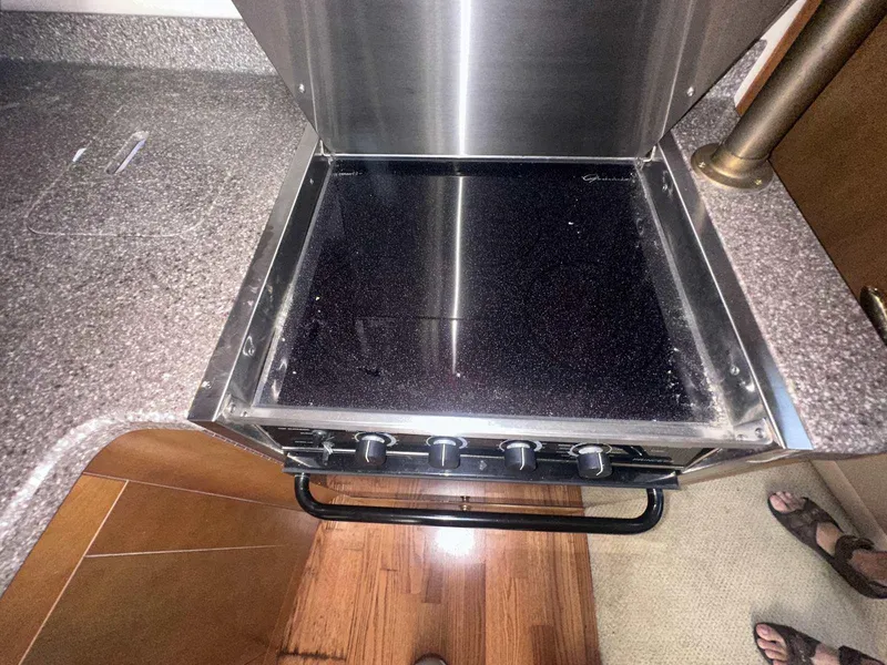 Slide: The Image of Stovetop in 2004 Rinker Fiesta Vee 410 yacht kitchen, featuring sleek design and controls. - 28