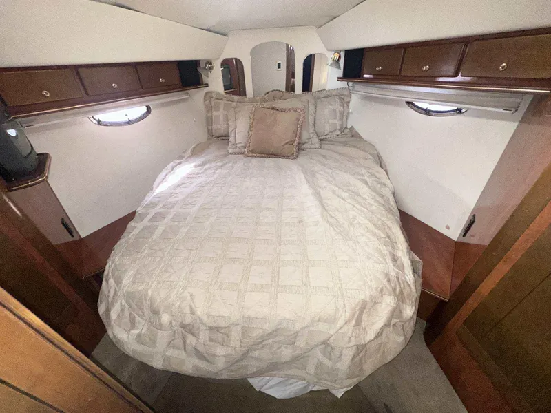 Slide: The Image of Luxurious cabin interior of 2004 Rinker Fiesta Vee 410 with cozy bed and wooden cabinets. - 30