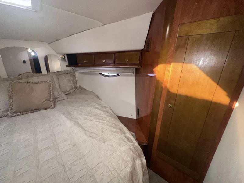 Slide: The Image of Interior cabin of 2004 Rinker Fiesta Vee 410 with bed and wooden cabinetry. - 32