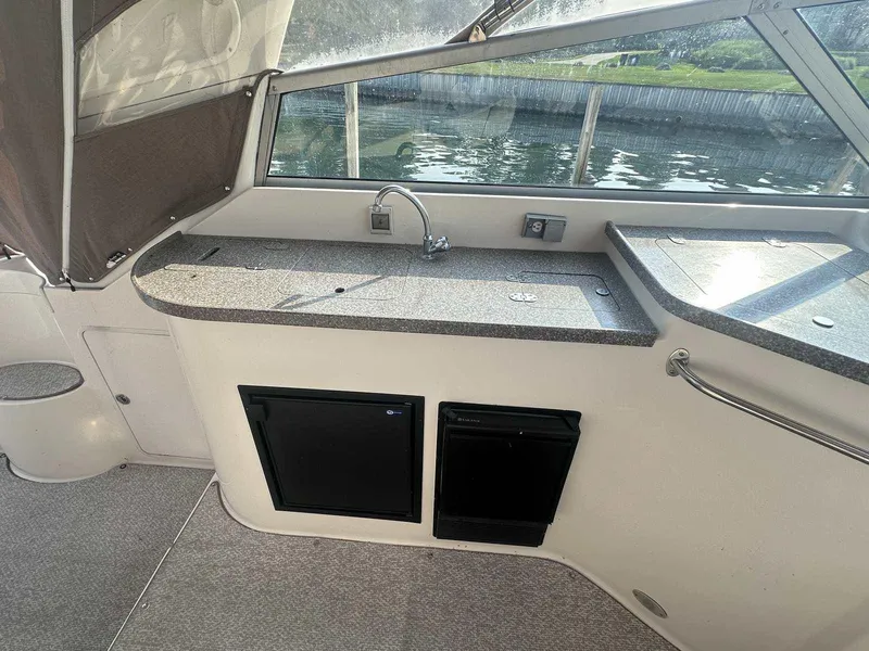 Slide: The Image of 2004 Rinker Fiesta Vee 410 boat interior with kitchenette and water view. - 5