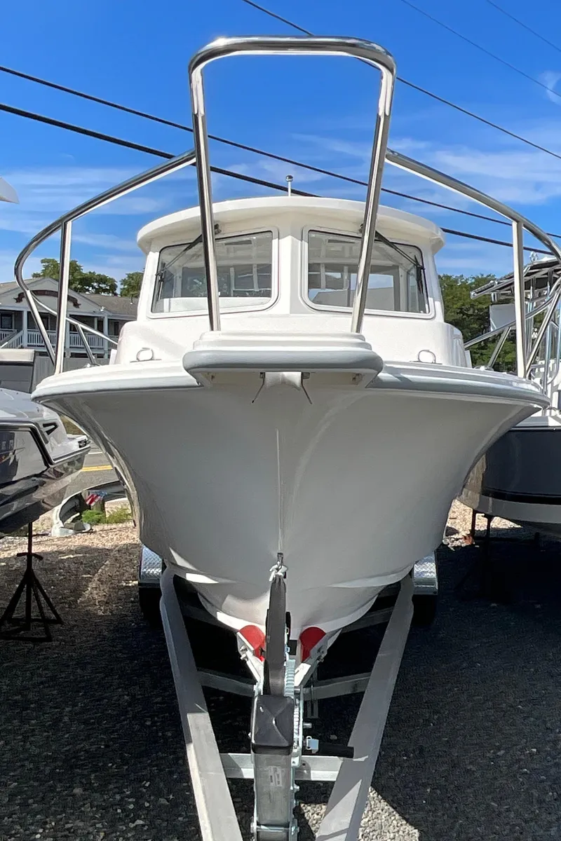 Slide: The Image of 2026 NorthCoast 255 HT boat on trailer, front view under clear blue sky. - 13