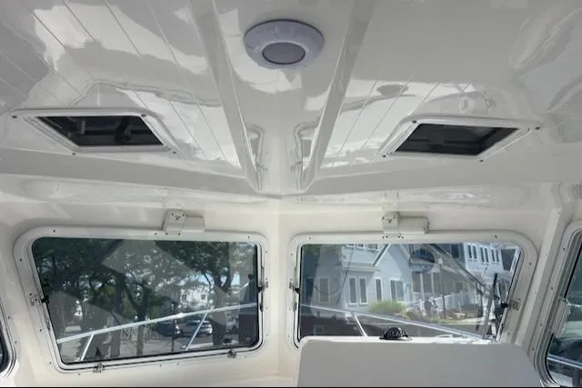 Slide: The Image of Interior view of 2026 NorthCoast 255 HT boat, featuring windows and ceiling hatches. - 14