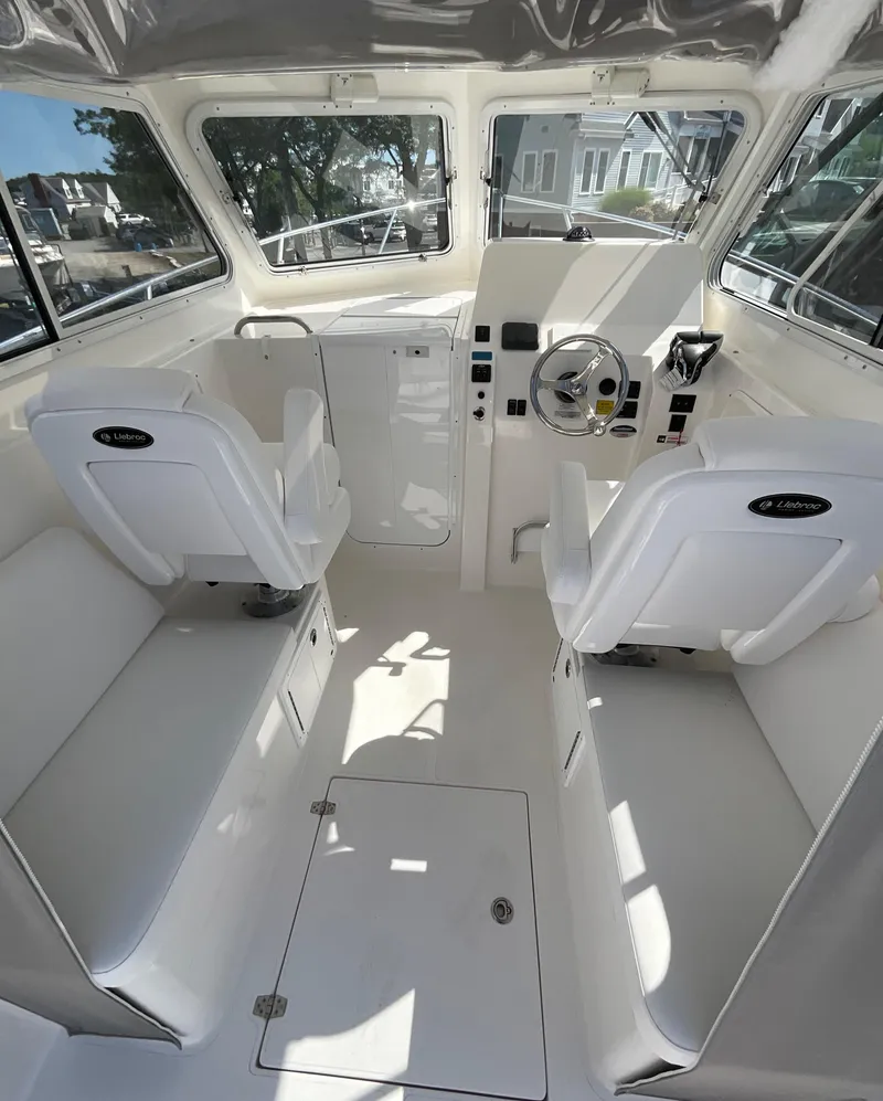 Slide: The Image of Interior of 2026 NorthCoast 255 HT boat with white seating and steering console. - 3