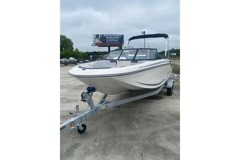 Slide: The Image of 2025 Bayliner Element M17 boat on trailer, parked outdoors under cloudy sky. - 2