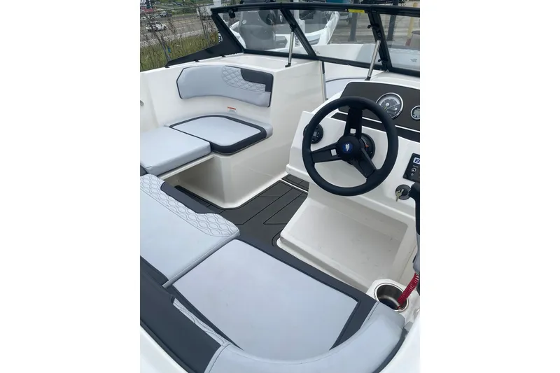 Slide: The Image of 2025 Bayliner Element M17 boat interior with steering wheel and cushioned seating. - 7