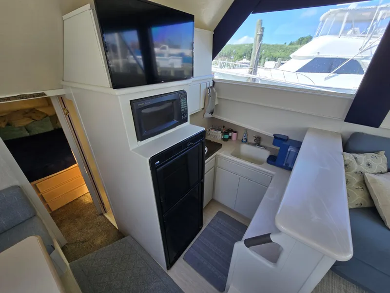 Slide: The Image of Interior of 1998 Henriques 38 Sportfisherman with kitchenette, microwave, and seating area. - 11