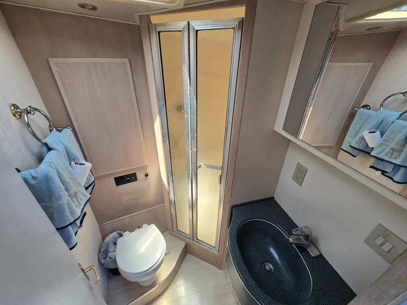 Slide: The Image of Bathroom interior of 1998 Henriques 38 Sportfisherman, featuring shower, sink, and toilet. - 16